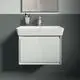 Waschbecken mit minimalistischer weißen Oberfläche und integrierter Armatur, montiert an einer grauen Wand, Teil der Ideal Standard Produktlinie.